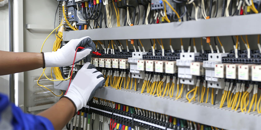 homem fazendo manutenção em um painel de energia de uma empresa