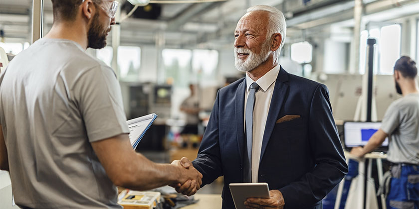 dono de uma empresa apertando as mãos de um funcionário