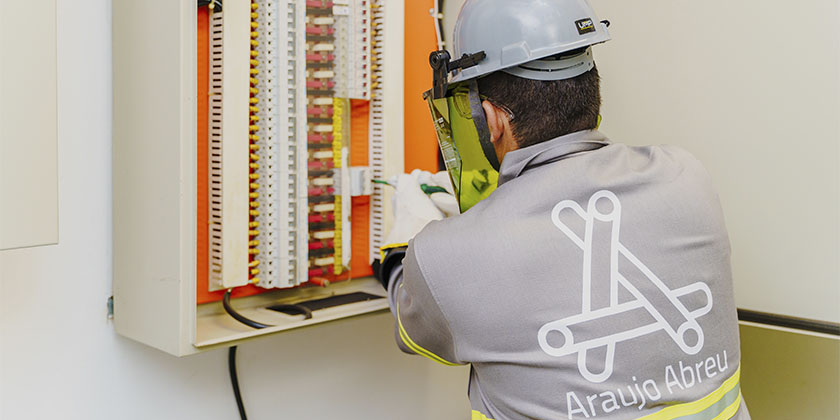 colaborador da Araújo Abreu fazendo manutenção em um painel de energia