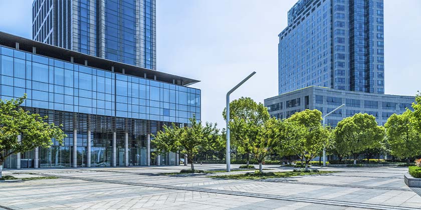 prédios comerciais com fachada de vidro em uma parte arborizada da cidade