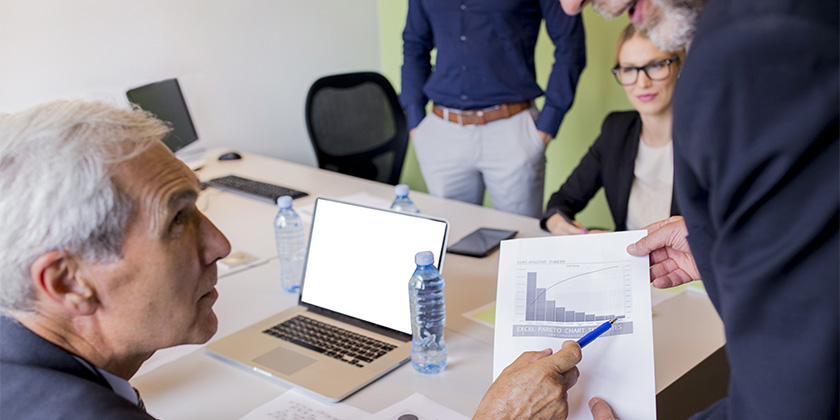 Empresários em uma reunião analisando a performance da empresa depois de uma gestão de facilities de sucesso.