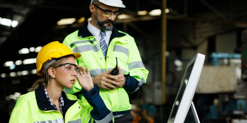 Profissionais capacitados em tecnologia da informação usando um computador para ampliar a gestão de facilities de uma empresa.